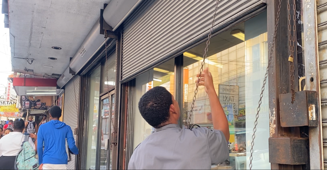 Closing time: A security guard the shutters on a business place on High Street, San Fernando, on March 24, 2026.